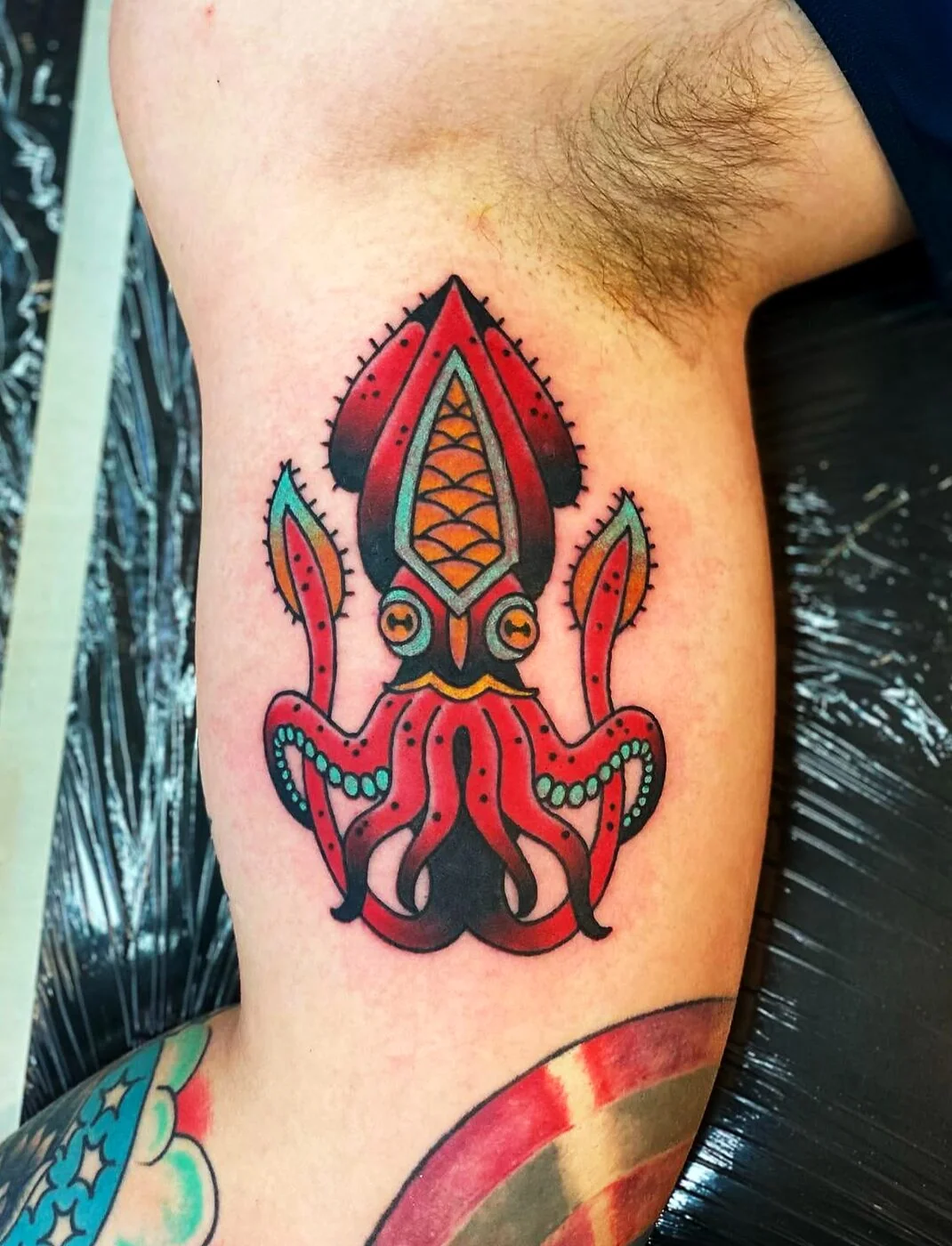 American Traditional red squid with green tentacle accents tattoo on bicep by 2bit (Chris Curren) at Lost at Sea Tattoo, Chinatown, Honolulu American Traditional red squid with green tentacle accents tattoo on bicep by 2bit (Chris Curren) at Lost at Sea Tattoo, Chinatown, Honolulu