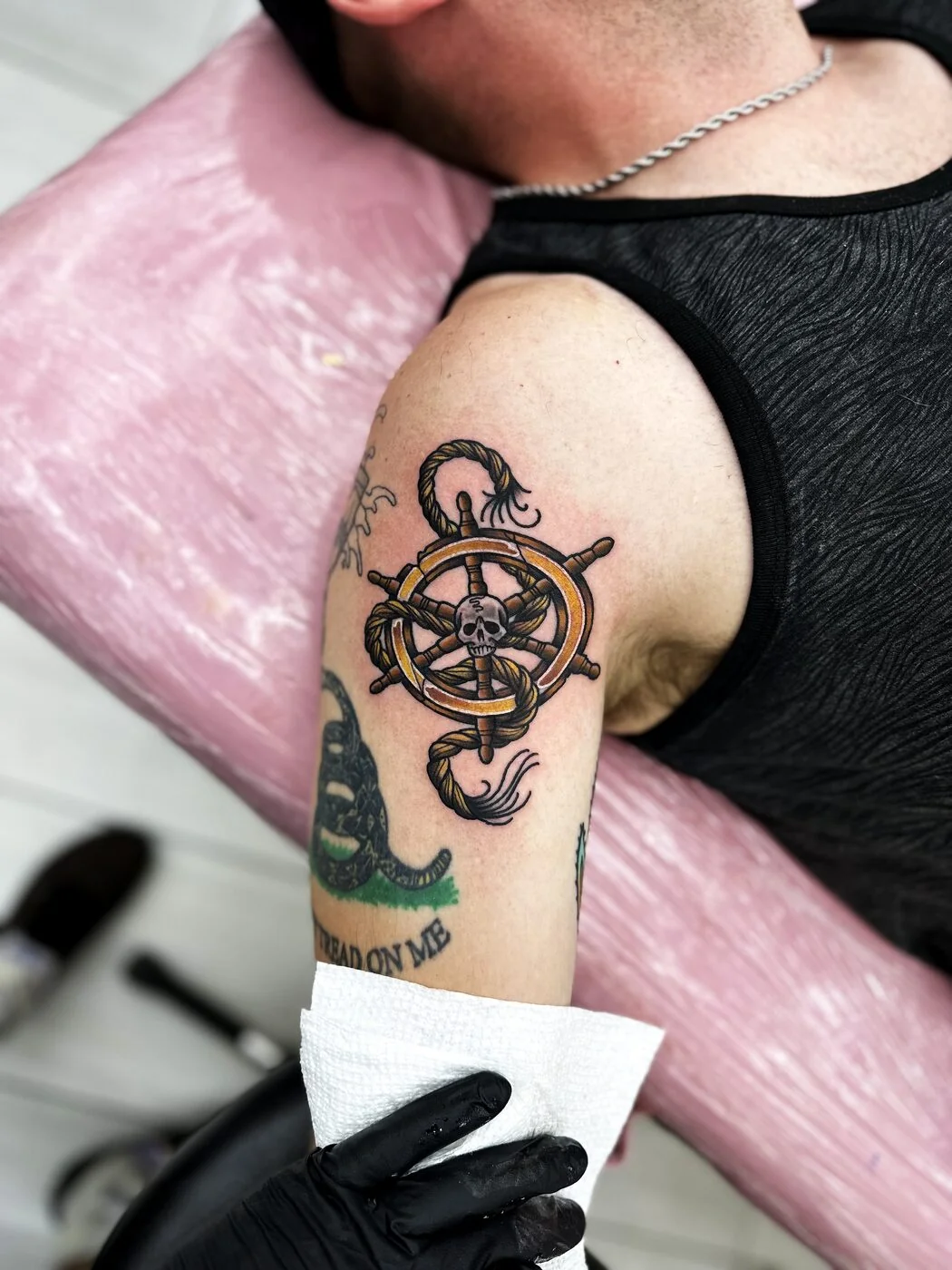 American Traditional ship's wheel with skull, rope and snake tattoo on shoulder by 2bit (Chris Curren) at Lost at Sea Tattoo, Chinatown, Honolulu American Traditional ship's wheel with skull, rope and snake tattoo on shoulder by 2bit (Chris Curren) at Lost at Sea Tattoo, Chinatown, Honolulu