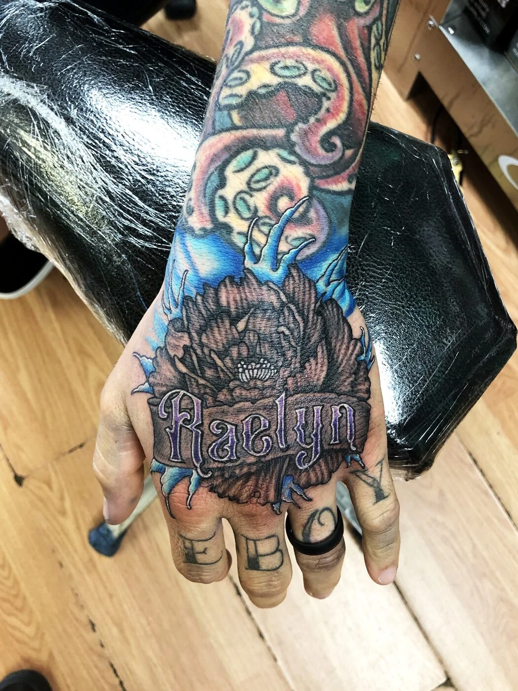 Color Realism octopus tentacles and peony with name banner tattoo on hand by 2bit (Chris Curren) at Lost at Sea Tattoo, Chinatown, Honolulu Color Realism octopus tentacles and peony with name banner tattoo on hand by 2bit (Chris Curren) at Lost at Sea Tattoo, Chinatown, Honolulu