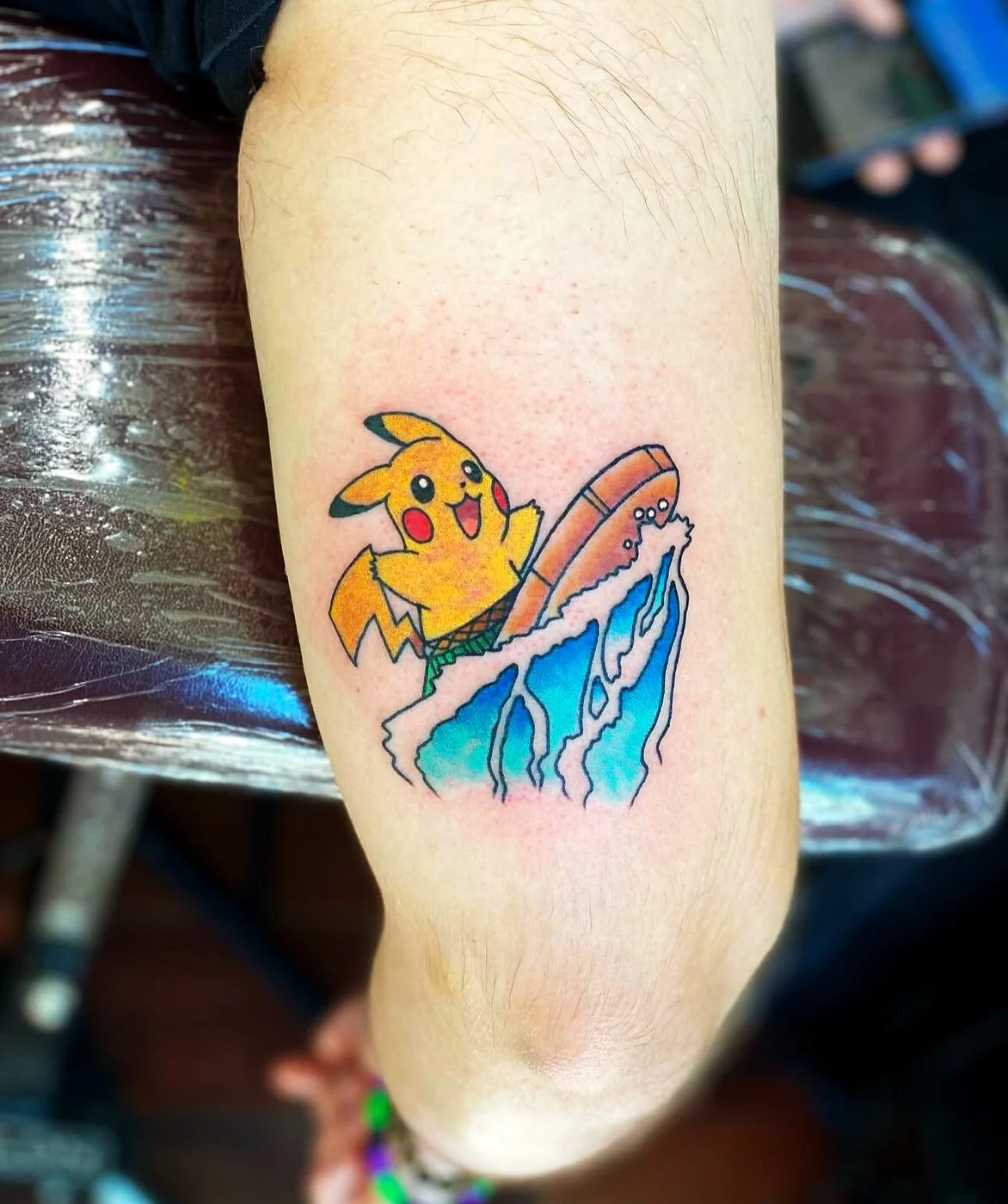 Illustrative Pikachu surfing a wave tattoo on calf by 2bit (Chris Curren) at Lost at Sea Tattoo, Chinatown, Honolulu Illustrative Pikachu surfing a wave tattoo on calf by 2bit (Chris Curren) at Lost at Sea Tattoo, Chinatown, Honolulu